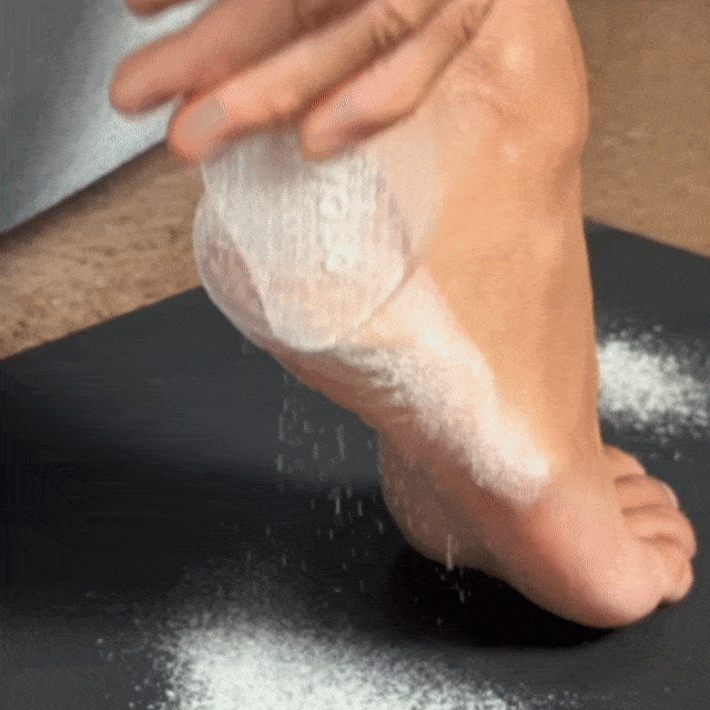 CheekyGlo Glass Foot File being scrubbed across the heel to buff away rough, dry, calloused skin and reveal smoother feet.