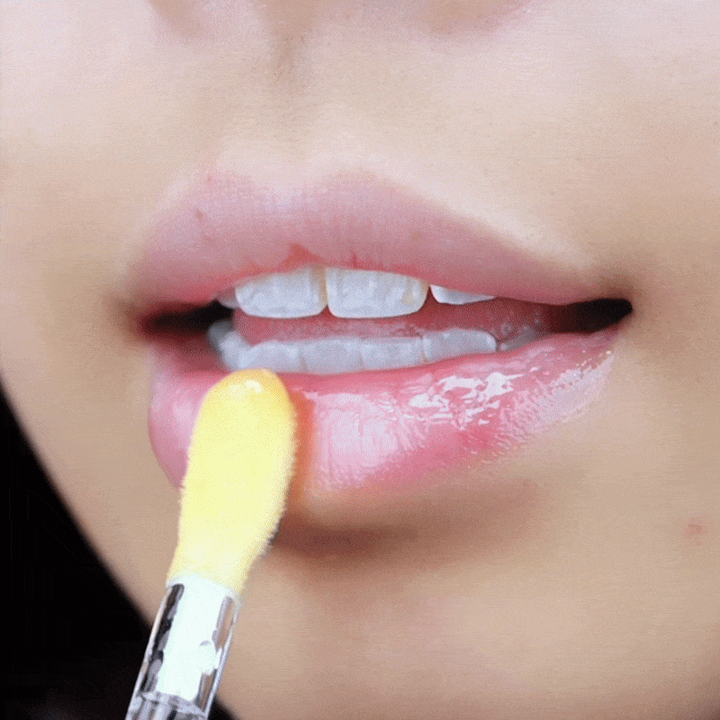 cheelyglo colour changing lip oil in coral shade being applied on the lips