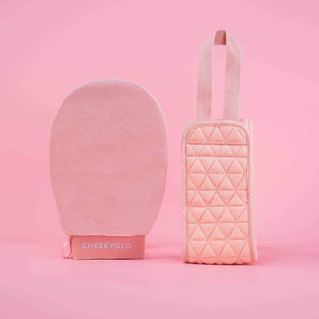 The Exfoliating Body Duo by CheekyGlo, featuring a pink exfoliating glove made from biodegradable viscose and a coordinating quilted pouch with a convenient top handle, is showcased against a pink background. The pouch pairs perfectly with the glove labeled "CHEEKYGLO.