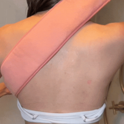 Woman scrubber her back with the CheekyGlo Back Scrubber in the Shower