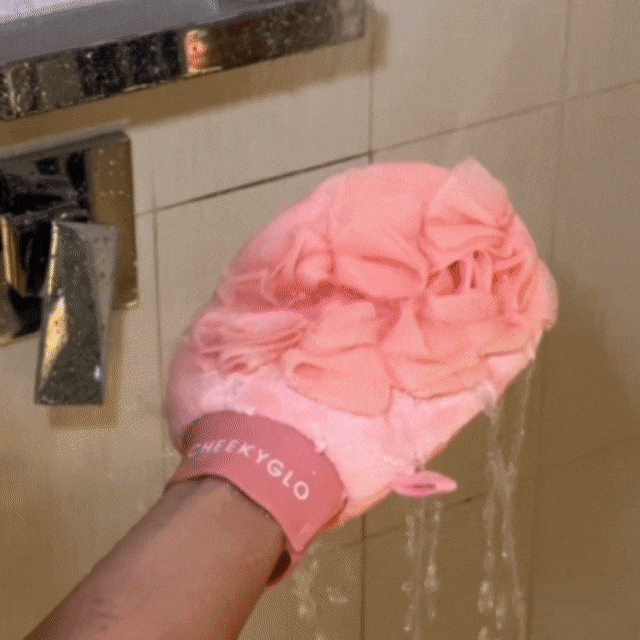 CheekyGlo Exfoliating Loofah Glove being rubbed over the skin to buff away dead skin, cleanse, and leave the body soft and smooth.