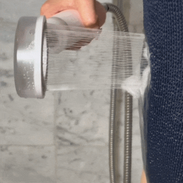 Woman showering with the CheekyGlo SkinVita Shower Filter, rinsing in filtered water for softer skin and hair.