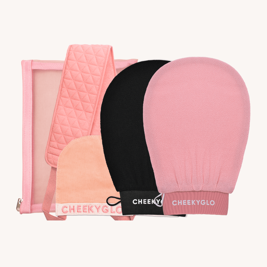 The CheekyGlo Ultimate Glow Set + Free Makeup Bag features a selection of exfoliating accessories, including pink and black mitts, a quilted pink band, and a convenient carrying pouch. Elegantly presented on a light background, this set blends functionality with style.