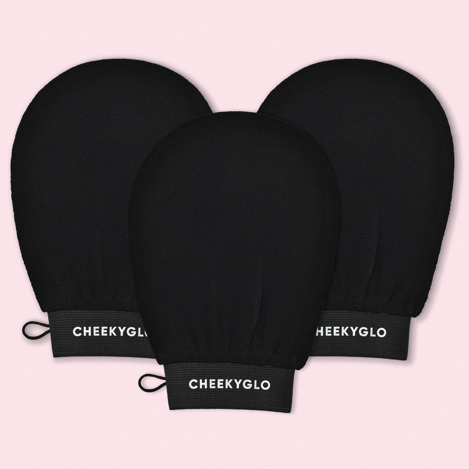 A set of three CheekyGlo Exfoliating Gloves in black are displayed against a light pink background, each featuring the &quot;CheekyGlo&quot; brand name in white on the wristband. These gloves are designed to help you achieve smoother, healthier skin with every use.