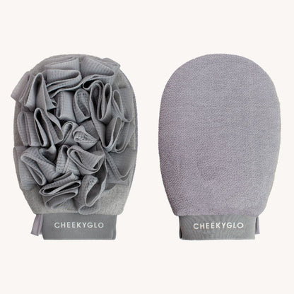 Two CheekyGlo Exfoliating Loofah Gloves are shown. The left glove features textured fabric loops and folds for scrubbing, making it ideal for tackling keratosis pilaris, while the right mitt has a smooth, soft surface for gentle skin smoothing. Both gloves display the word &quot;CHEEKYGLO&quot; at the bottom.