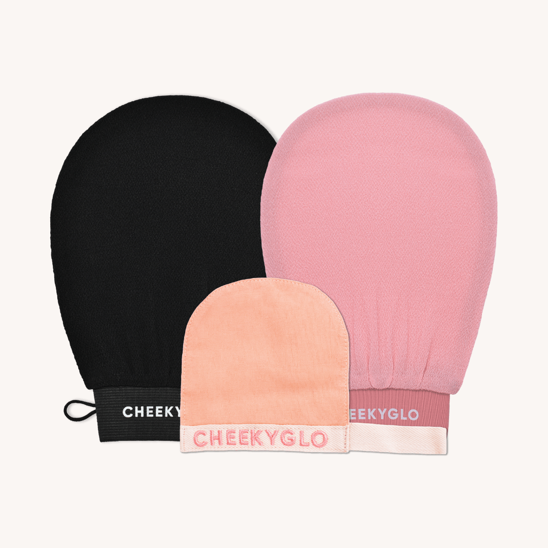 Image of the CheekyGlo Exfoliating Trio arranged against a light background: a large black body glove, a medium-sized pink glove, and a small peach glove. All gloves display the &quot;CHEEKYGLO&quot; logo near the wrist area.