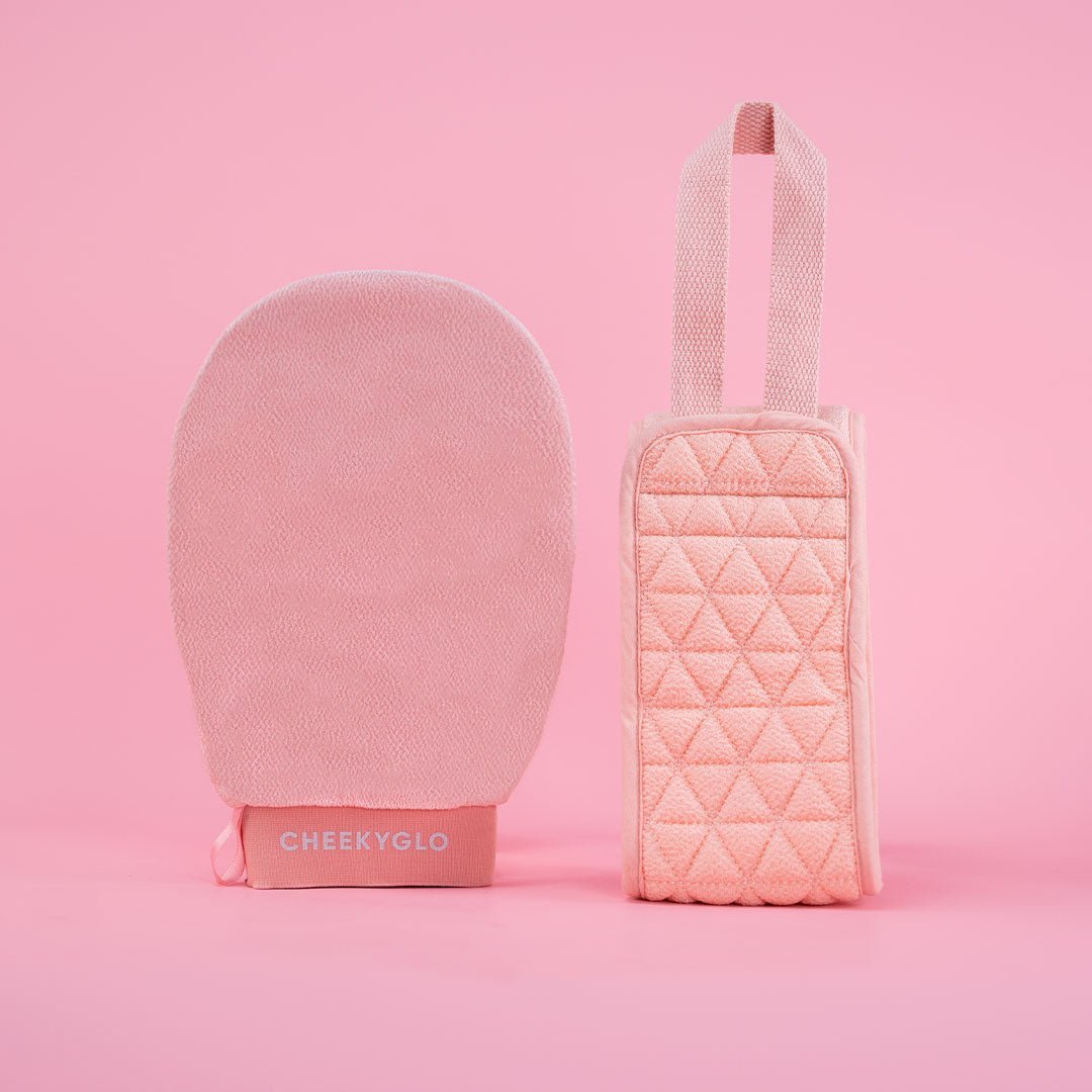 The Exfoliating Body Duo by CheekyGlo, featuring a pink exfoliating glove made from biodegradable viscose and a coordinating quilted pouch with a convenient top handle, is showcased against a pink background. The pouch pairs perfectly with the glove labeled &quot;CHEEKYGLO.